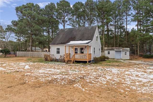 cape cod house with a wooden deck and a storage shed