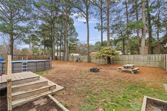 view of yard featuring an outdoor fire pit and a pool side deck