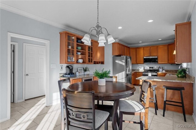 kitchen with appliances with stainless steel finishes, sink, kitchen peninsula, light tile patterned floors, and crown molding