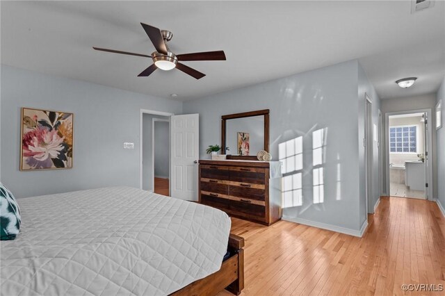 bedroom featuring ceiling fan, ensuite bathroom, and light hardwood / wood-style flooring