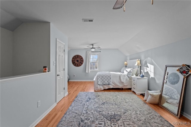 bedroom featuring light wood-type flooring, vaulted ceiling, and ceiling fan