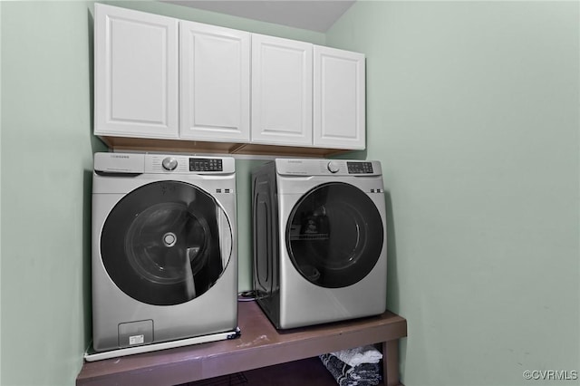 laundry area featuring washing machine and clothes dryer and cabinets