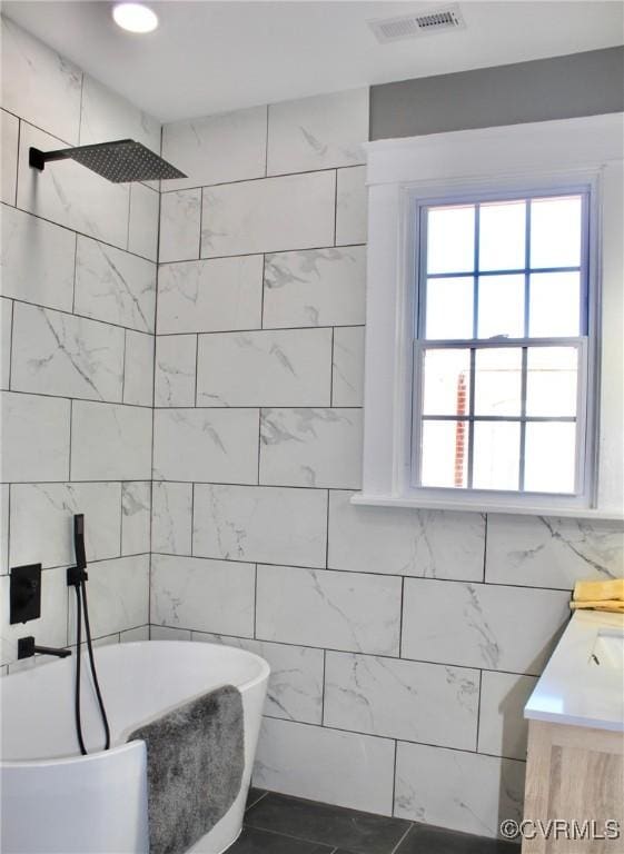 bathroom with tile walls, tile patterned floors, independent shower and bath, and vanity