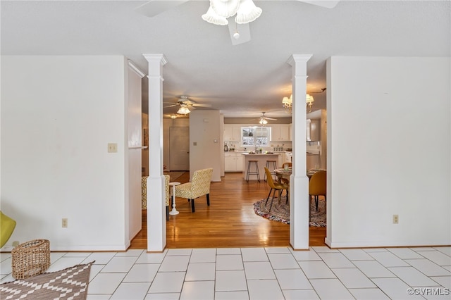 interior space featuring ceiling fan, light tile patterned floors, and ornate columns