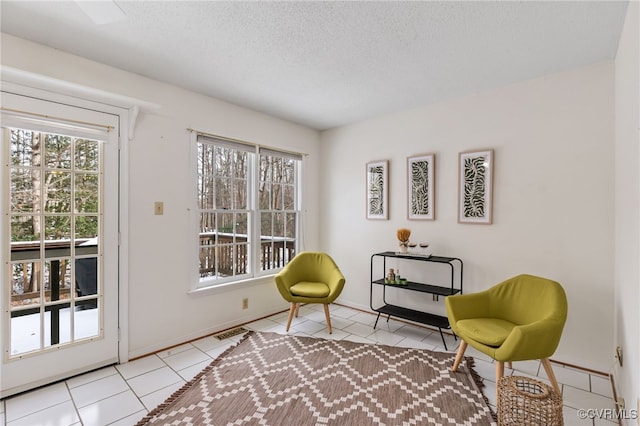 sitting room featuring light tile patterned flooring and a textured ceiling