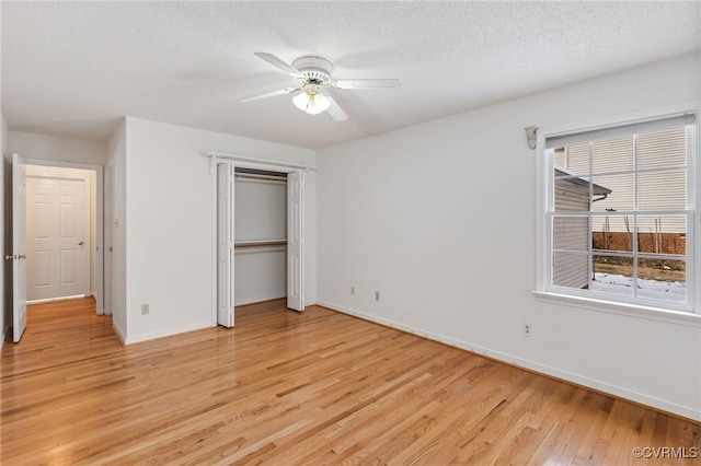 unfurnished bedroom with ceiling fan, light hardwood / wood-style floors, and a textured ceiling