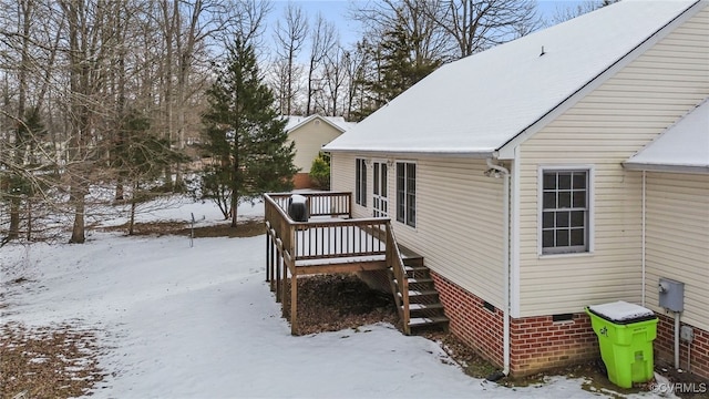 view of snowy exterior with a deck