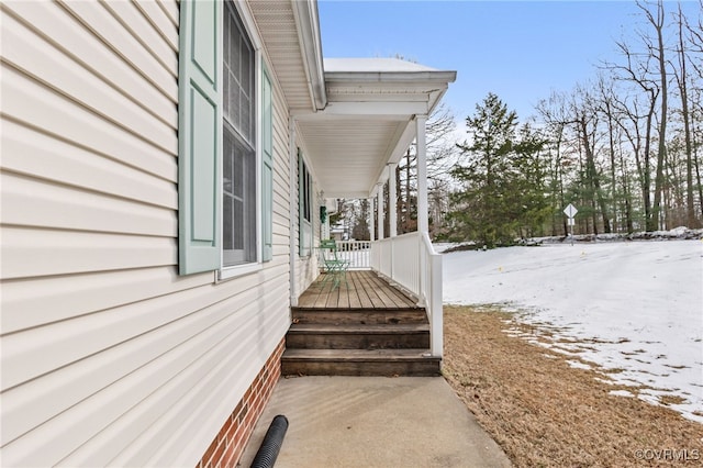 view of snowy exterior featuring a porch