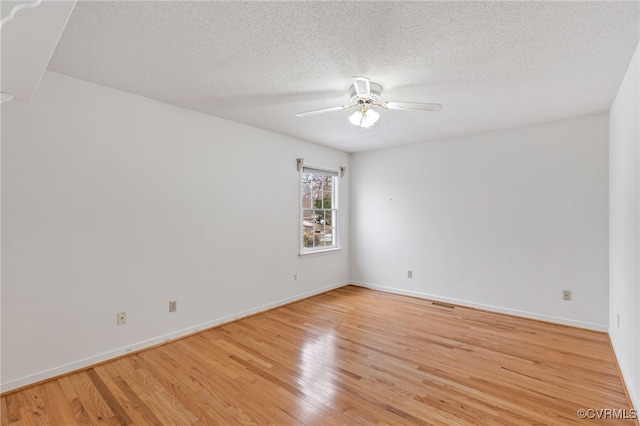 spare room with ceiling fan, a textured ceiling, and light wood-type flooring