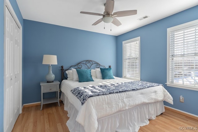 bedroom with ceiling fan, light hardwood / wood-style flooring, and a closet