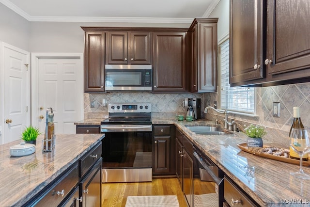 kitchen featuring light stone countertops, dark brown cabinetry, crown molding, appliances with stainless steel finishes, and sink