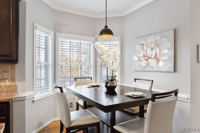 dining area featuring a healthy amount of sunlight, light hardwood / wood-style flooring, and ornamental molding