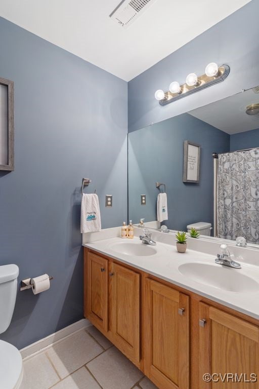 bathroom with tile patterned flooring, vanity, and toilet