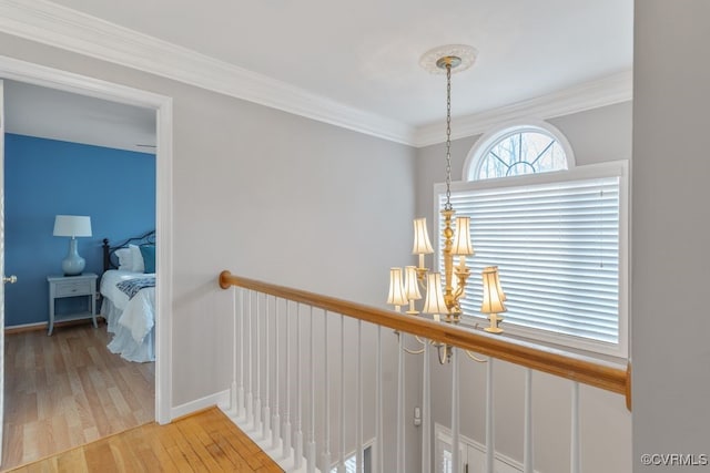 hallway with light wood-type flooring and crown molding