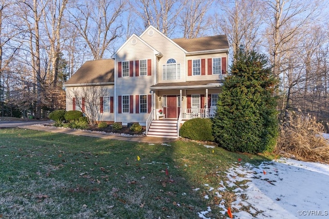 colonial home featuring a porch and a lawn