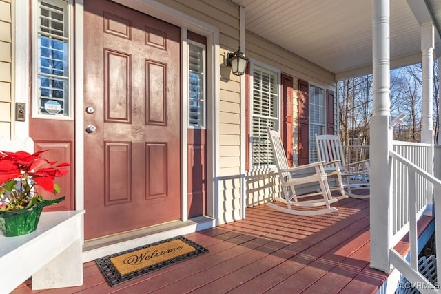 view of exterior entry featuring covered porch