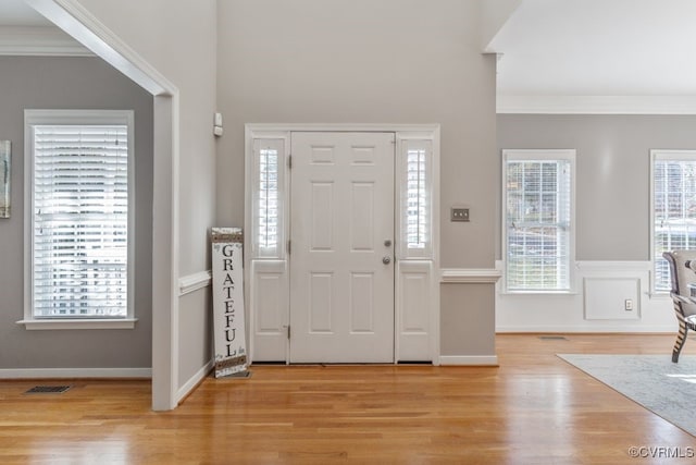 entrance foyer with light wood-type flooring and crown molding