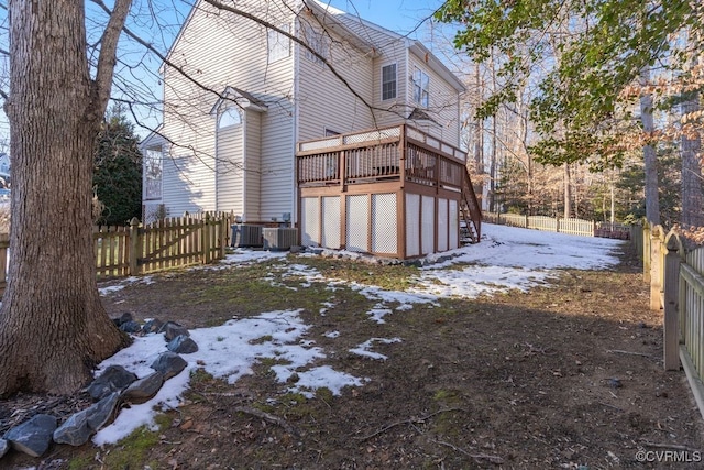 yard layered in snow with a deck and cooling unit