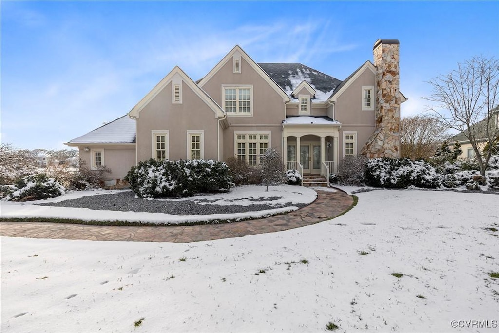 snow covered house featuring french doors