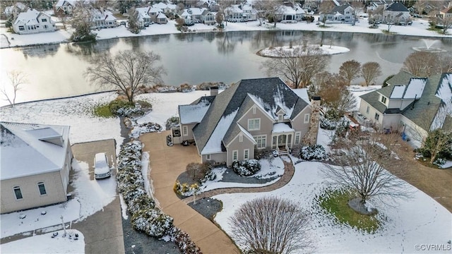 snowy aerial view featuring a water view