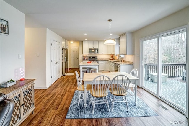 dining area featuring sink and light wood-type flooring