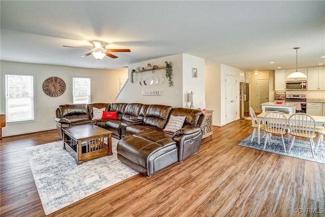 living room featuring light hardwood / wood-style flooring and ceiling fan