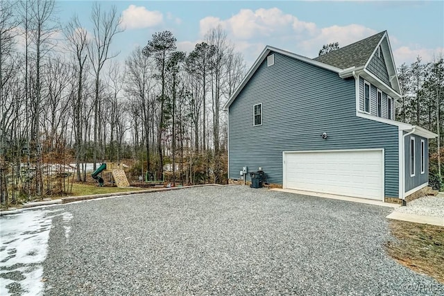 view of side of property featuring a playground and a garage