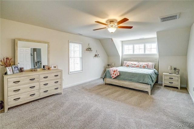 bedroom with ceiling fan, light colored carpet, and vaulted ceiling