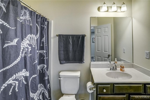 bathroom featuring toilet, vanity, and walk in shower