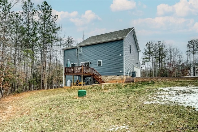 rear view of house featuring a garage, a yard, and a deck