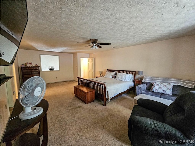 carpeted bedroom featuring a ceiling fan and a textured ceiling