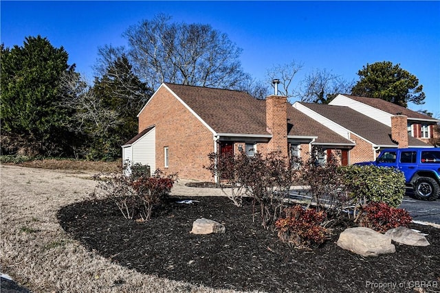 exterior space featuring a chimney and brick siding