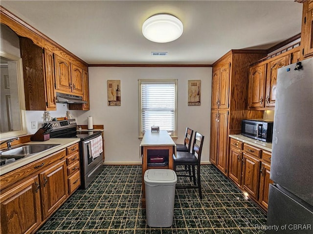 kitchen with visible vents, brown cabinets, stainless steel appliances, light countertops, and under cabinet range hood