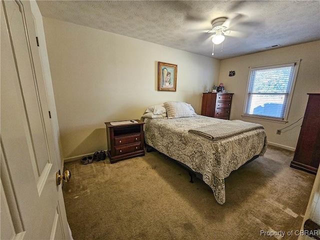 bedroom featuring carpet floors, visible vents, a textured ceiling, and baseboards