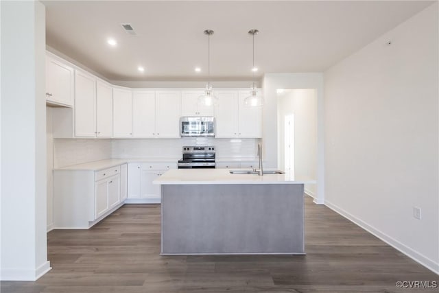 kitchen with pendant lighting, stainless steel appliances, an island with sink, white cabinets, and sink