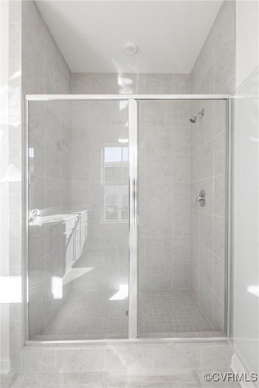 bathroom with tile patterned flooring and a shower with door