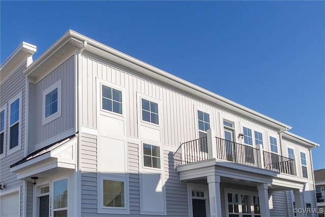 view of side of property with a balcony and a garage