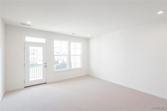 spare room featuring light colored carpet