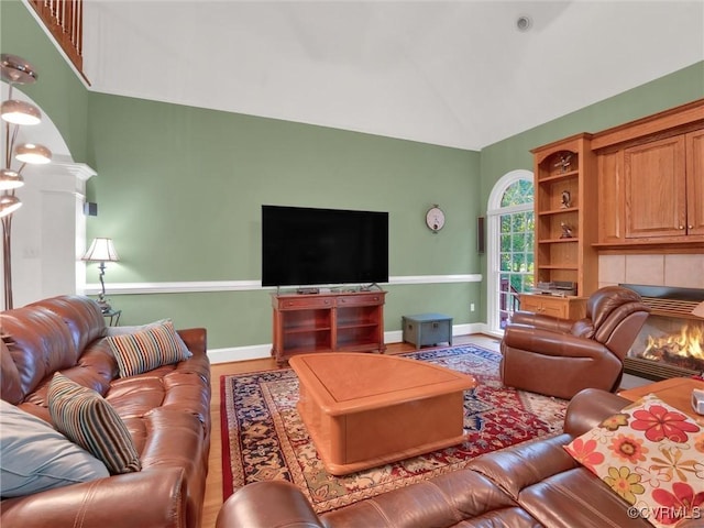 living room with hardwood / wood-style flooring, vaulted ceiling, and a fireplace