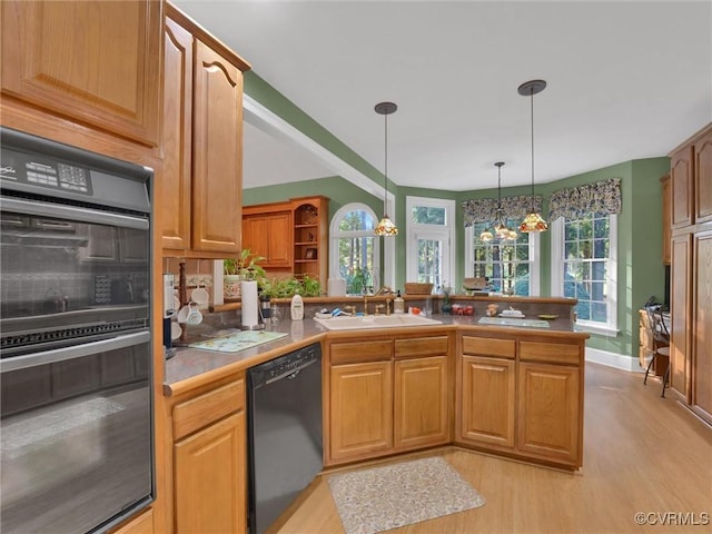 kitchen featuring kitchen peninsula, hanging light fixtures, black appliances, an inviting chandelier, and sink