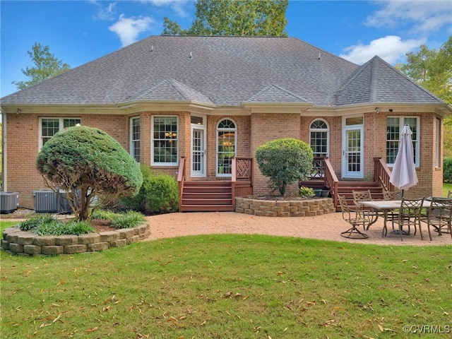 back of house with central AC, a yard, and a patio