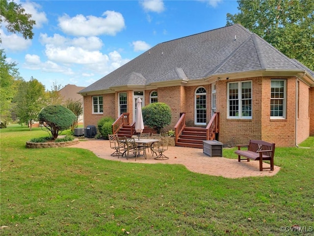 rear view of property with a patio, a yard, and central air condition unit