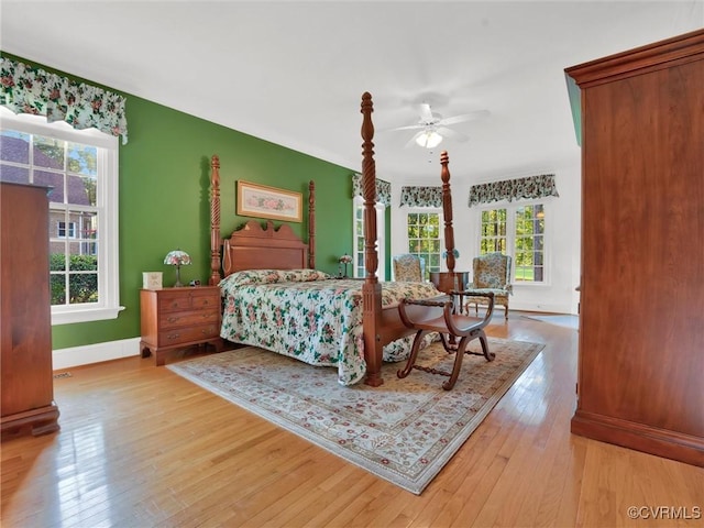 bedroom featuring multiple windows, ceiling fan, and light hardwood / wood-style flooring