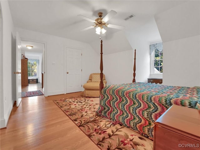 bedroom with ceiling fan, light hardwood / wood-style flooring, and multiple windows