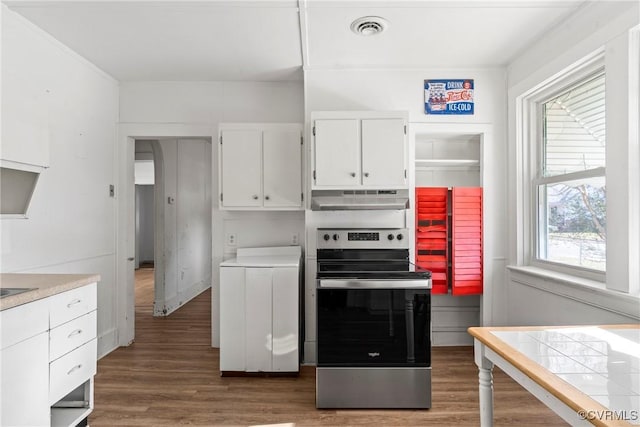 kitchen featuring washer / dryer, white cabinetry, a wealth of natural light, and stainless steel electric range oven