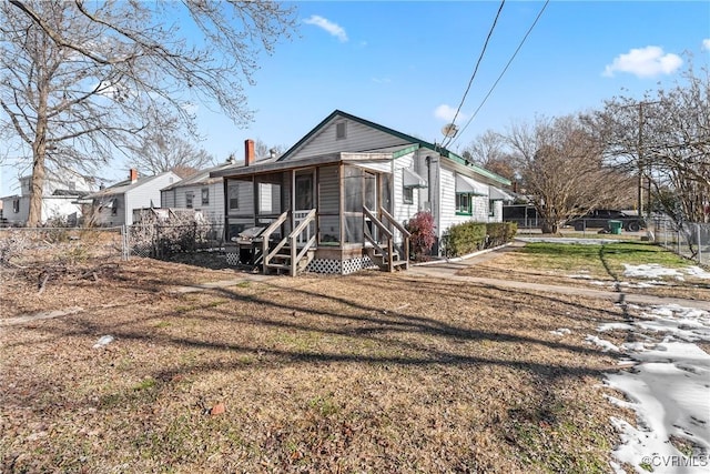 back of house featuring a yard and a sunroom