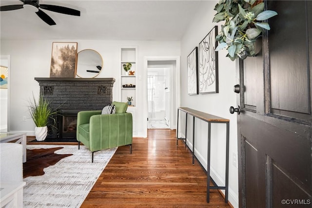 entryway featuring a fireplace, ceiling fan, and dark hardwood / wood-style floors