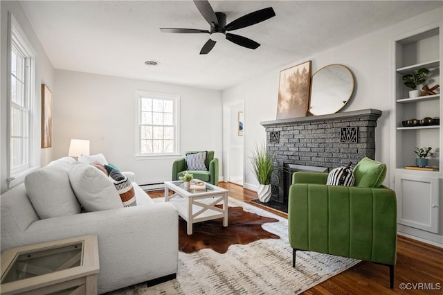 living room featuring ceiling fan, dark wood-type flooring, built in features, and plenty of natural light