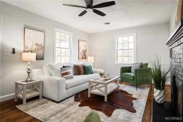 living room with a fireplace, ceiling fan, a healthy amount of sunlight, and hardwood / wood-style floors