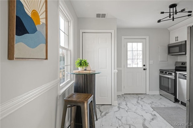 doorway to outside with a wealth of natural light and a notable chandelier